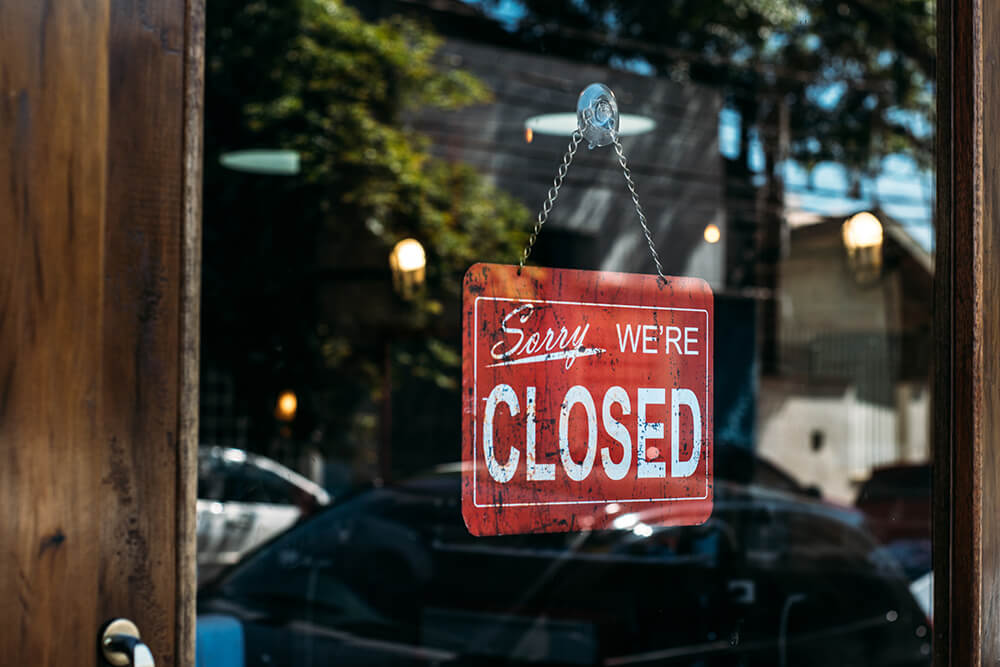 Sorry we're closed business sign hanging in door