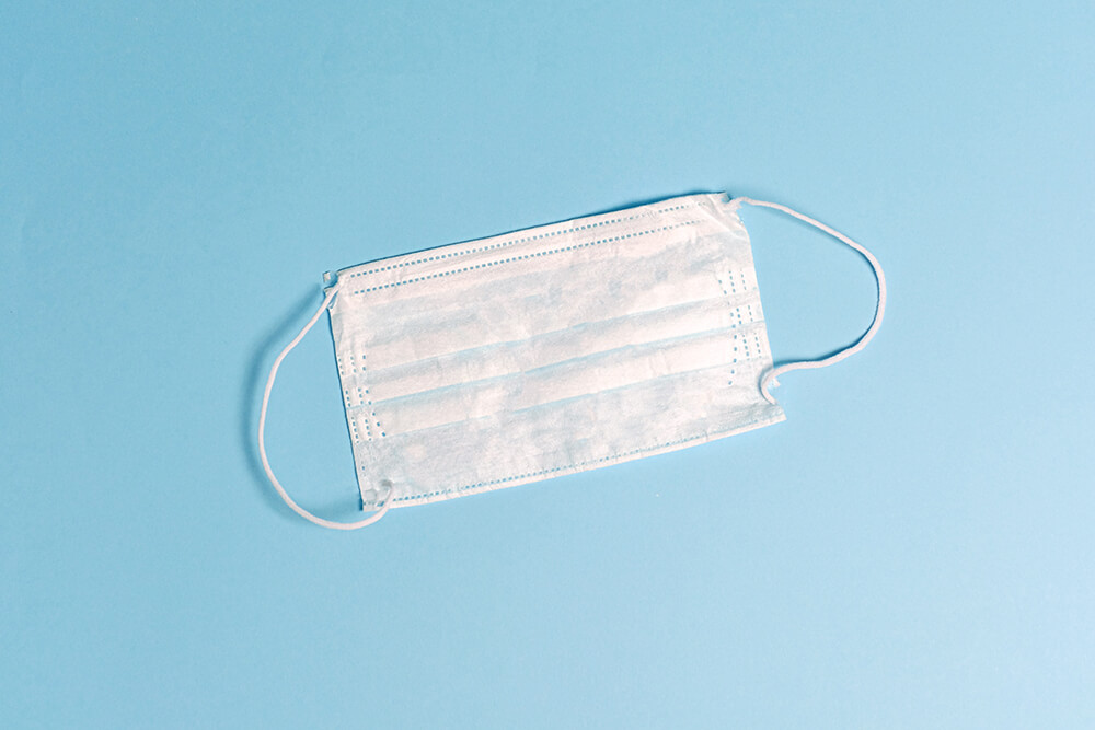 White medical mask on blue background